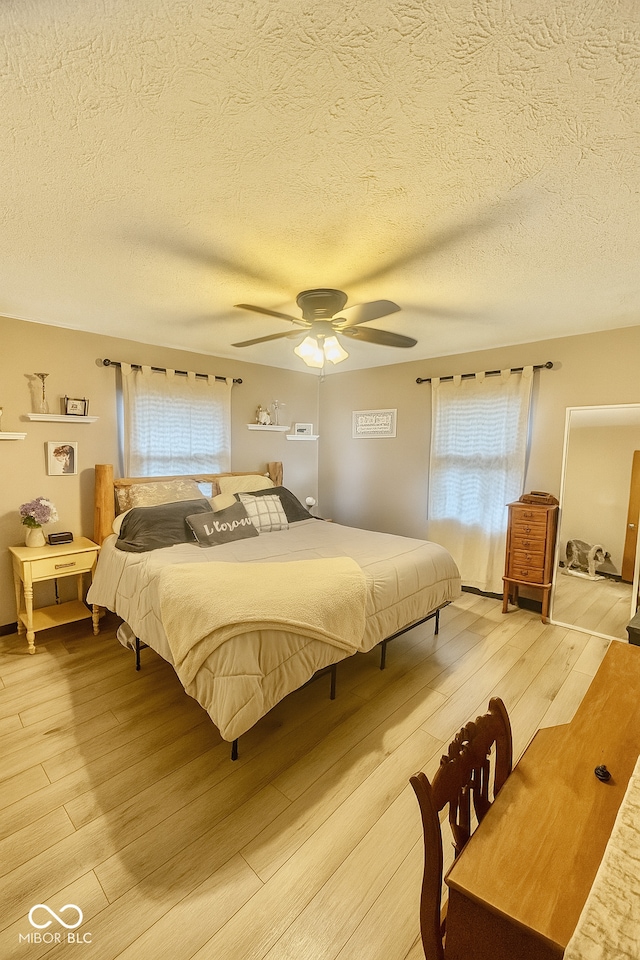 474 Mill, Coatesville, IN 46121 - bedroom featuring light wood-style floors, multiple windows, a textured ceiling, and ceiling fan
