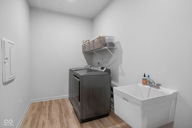 7210 Covington St, Lebanon, IN 46052 - washroom with laundry area, light wood-style flooring, a sink, baseboards, and washer and clothes dryer