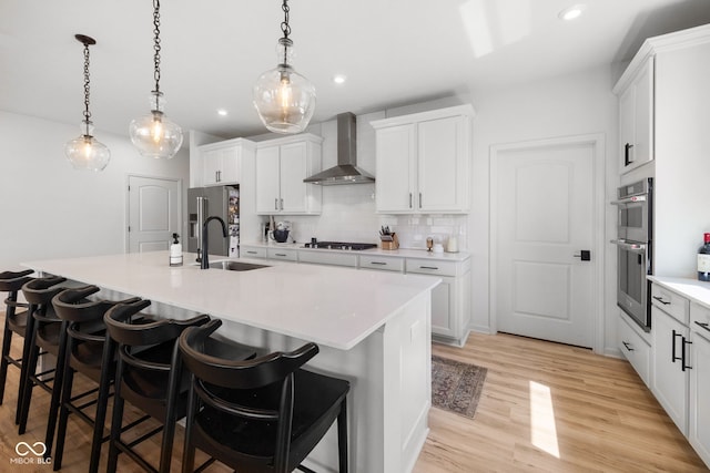 7210 Covington St, Lebanon, IN 46052 - kitchen featuring tasteful backsplash, a sink, wall chimney range hood, a kitchen bar, and stainless steel appliances