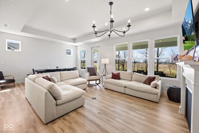 7210 Covington St, Lebanon, IN 46052 - living area with baseboards, a raised ceiling, a notable chandelier, light wood-style floors, and recessed lighting