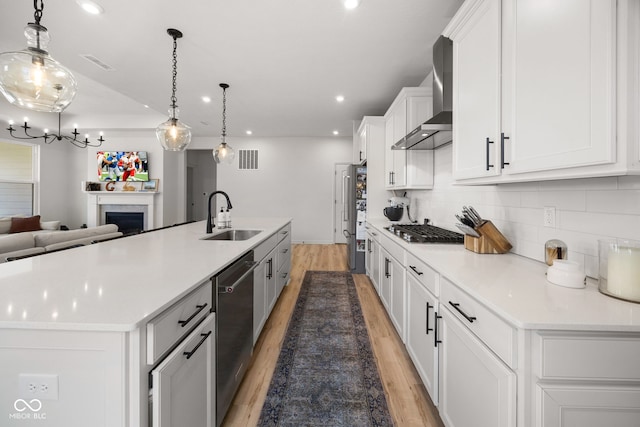 7210 Covington St, Lebanon, IN 46052 - kitchen featuring wall chimney exhaust hood, a large island, a sink, stainless steel appliances, and light wood finished floors