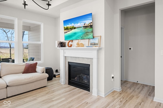7210 Covington St, Lebanon, IN 46052 - living room featuring baseboards, a glass covered fireplace, and wood finished floors