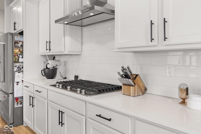 7210 Covington St, Lebanon, IN 46052 - kitchen featuring white cabinets, wall chimney range hood, light countertops, appliances with stainless steel finishes, and backsplash
