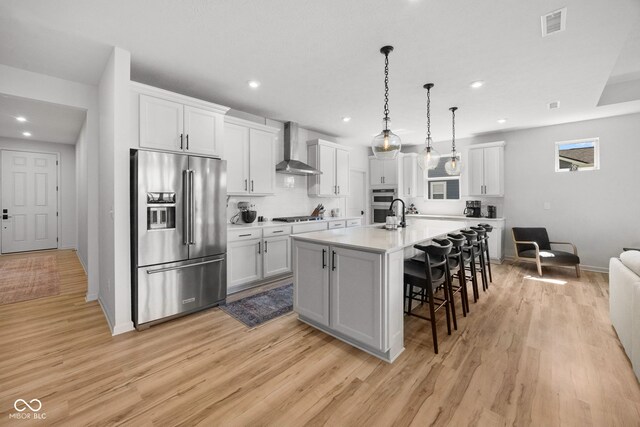 7210 Covington St, Lebanon, IN 46052 - kitchen featuring baseboards, wall chimney range hood, recessed lighting, a kitchen bar, and appliances with stainless steel finishes