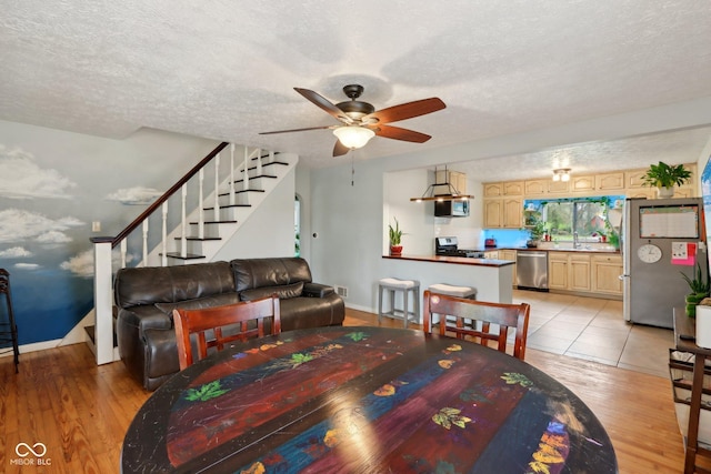 5945 Mcfarland Rd, Indianapolis, IN 46227 - dining space with visible vents, ceiling fan, light wood-type flooring, a textured ceiling, and stairs