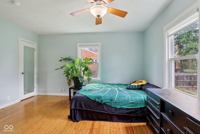 5945 Mcfarland Rd, Indianapolis, IN 46227 - bedroom featuring light wood-style floors, ceiling fan, baseboards, and multiple windows
