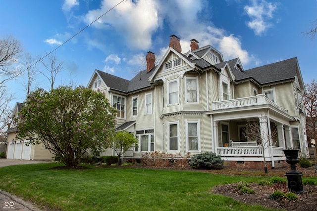 313 E Wabash Ave, Crawfordsville, IN 47933 - view of front of property with a balcony, a chimney, a front yard, a porch, and a garage