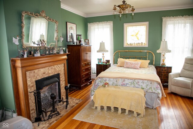 313 E Wabash Ave, Crawfordsville, IN 47933 - bedroom with ornamental molding, hardwood / wood-style floors, and a tile fireplace