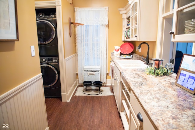 313 E Wabash Ave, Crawfordsville, IN 47933 - laundry area featuring a sink, laundry area, dark wood-style floors, stacked washer and dryer, and a wainscoted wall