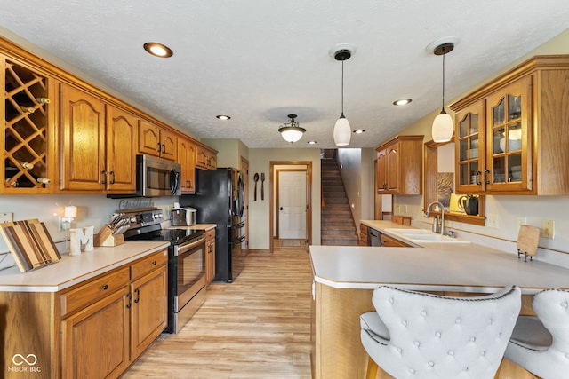 8095 Christopher Ct, Avon, IN 46123 - kitchen featuring a peninsula, a sink, glass insert cabinets, brown cabinets, and appliances with stainless steel finishes