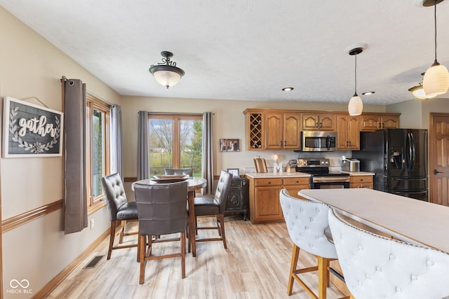8095 Christopher Ct, Avon, IN 46123 - kitchen featuring light countertops, brown cabinetry, light wood-type flooring, and stainless steel appliances