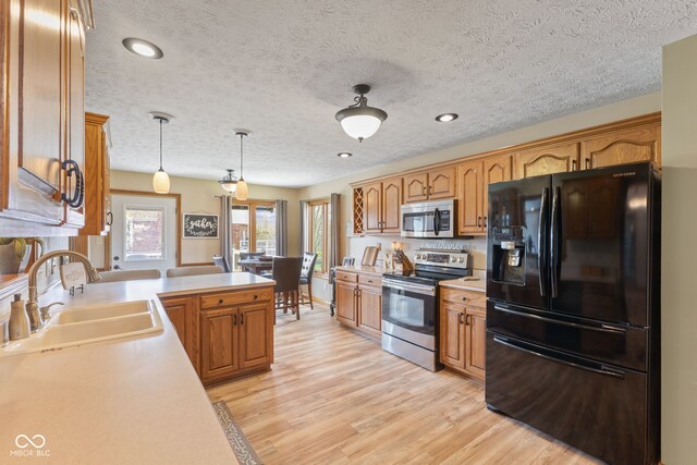 8095 Christopher Ct, Avon, IN 46123 - kitchen featuring stainless steel appliances, light countertops, a sink, and light wood-style floors