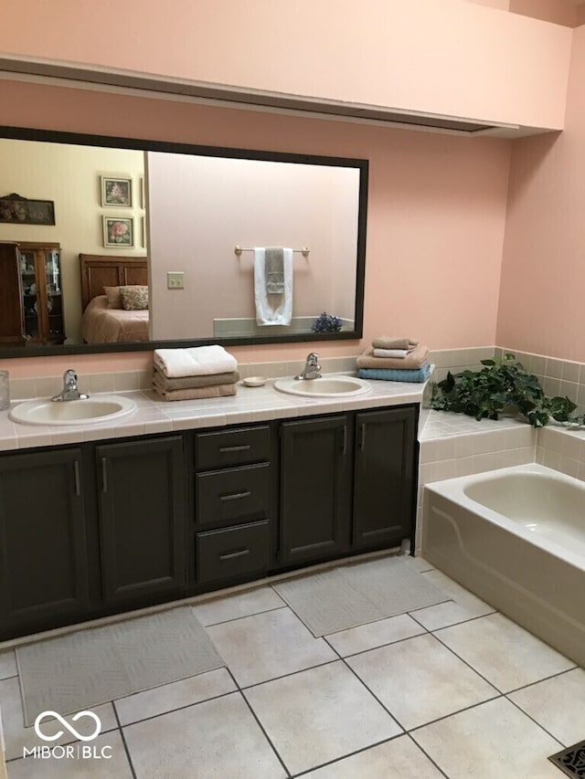 full bathroom with double vanity, a sink, and tile patterned flooring