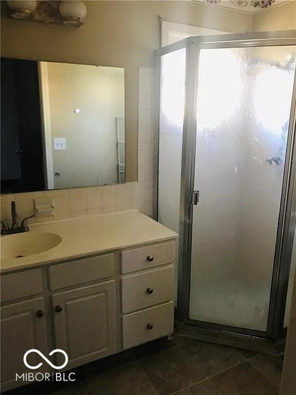 bathroom featuring a shower stall, vanity, and tile patterned flooring