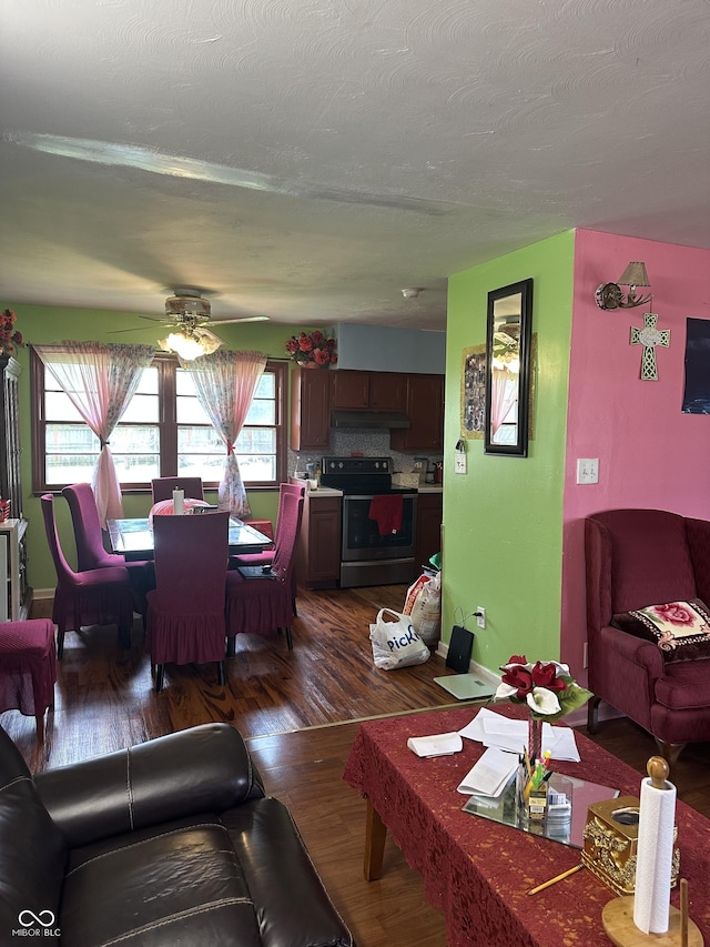 living room featuring baseboards, a ceiling fan, and dark wood finished floors