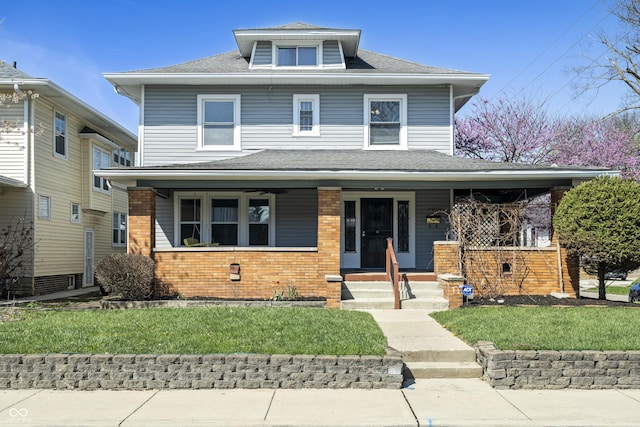 3970 Broadway St, Indianapolis, IN 46205 - american foursquare style home with brick siding, a front yard, covered porch, and roof with shingles