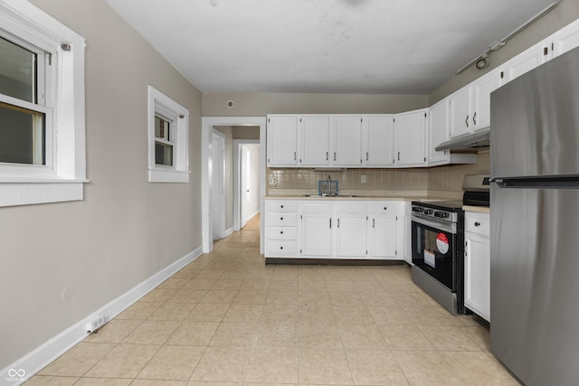 5713 Bluff Rd, Indianapolis, IN 46217 - kitchen with under cabinet range hood, white cabinetry, and appliances with stainless steel finishes