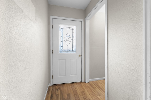 5713 Bluff Rd, Indianapolis, IN 46217 - doorway to outside with a textured wall, baseboards, and wood finished floors