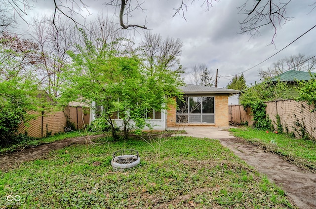 rear view of house featuring brick siding and fence