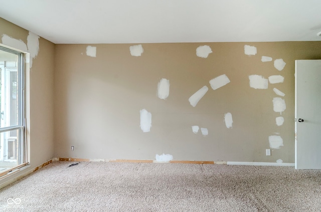 carpeted spare room featuring baseboards