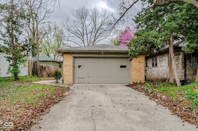 garage featuring fence and driveway