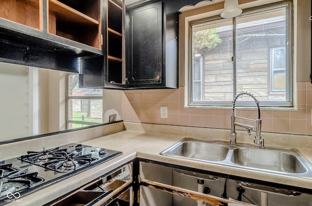 kitchen featuring decorative backsplash, black gas cooktop, a sink, and a healthy amount of sunlight