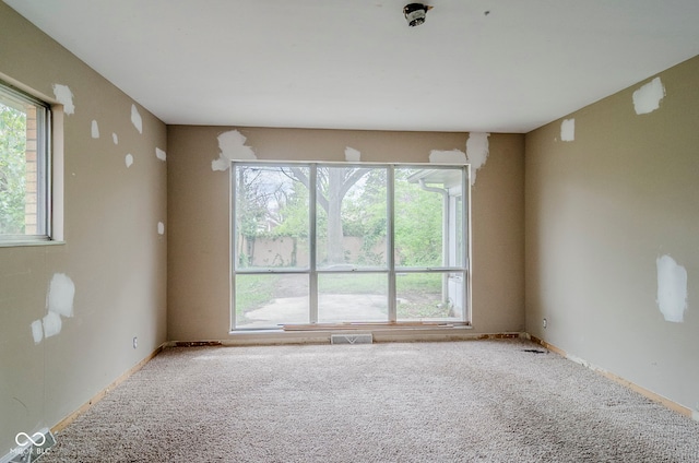 unfurnished room featuring carpet floors and visible vents