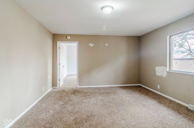 carpeted spare room featuring baseboards