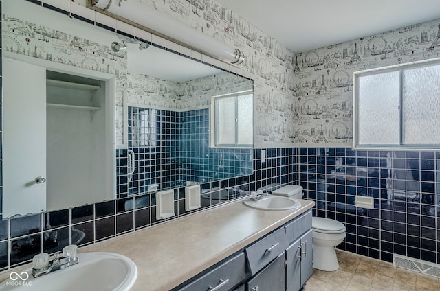 full bath featuring tile walls, visible vents, a sink, and toilet