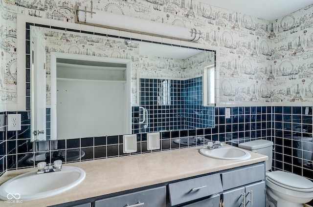 bathroom featuring tile walls, toilet, vanity, and decorative backsplash