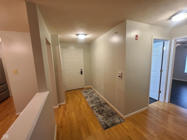 6525 Emerald Hill Ct Unit 208, Indianapolis, IN 46237 - hallway featuring a textured ceiling, light wood finished floors, and baseboards