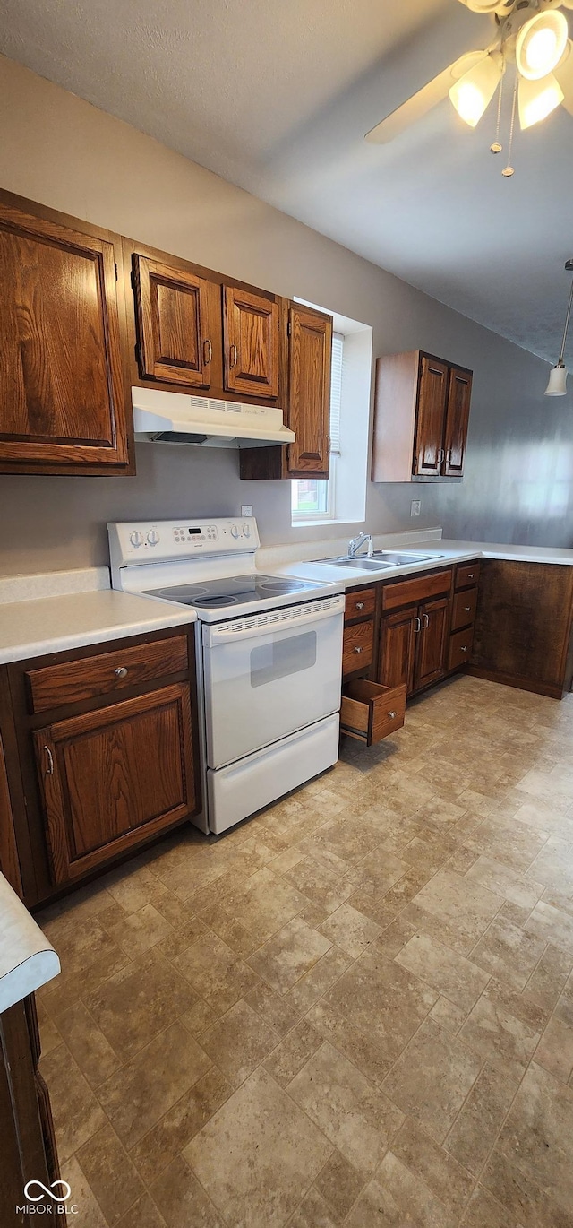 403 S Mill St, Veedersburg, IN 47987 - kitchen with under cabinet range hood, light countertops, stone finish flooring, and electric stove