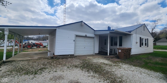 403 S Mill St, Veedersburg, IN 47987 - view of front of home featuring a carport, metal roof, an attached garage, driveway, and central AC unit