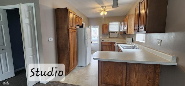 403 S Mill St, Veedersburg, IN 47987 - kitchen with white appliances, a peninsula, a ceiling fan, a sink, and light countertops