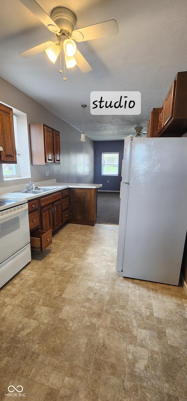 403 S Mill St, Veedersburg, IN 47987 - kitchen featuring white appliances, a peninsula, a ceiling fan, stone finish flooring, and a sink
