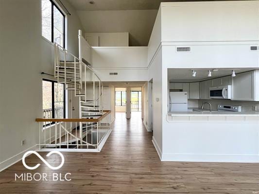 interior space with visible vents, baseboards, wood finished floors, and stairs