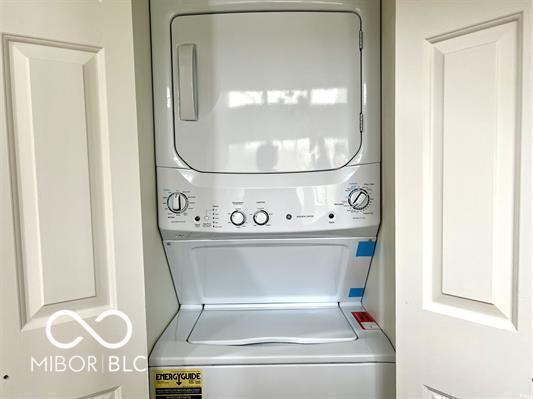 laundry area featuring stacked washer / dryer and laundry area