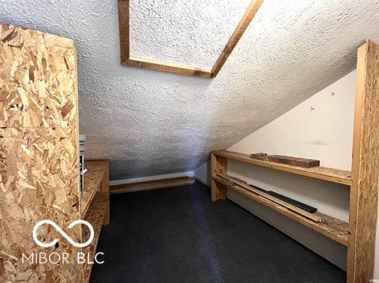 additional living space with a textured ceiling