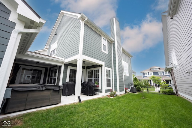 1534 Cloverdon Dr, Westfield, IN 46074 - back of property featuring a hot tub, central AC, a patio area, and a chimney