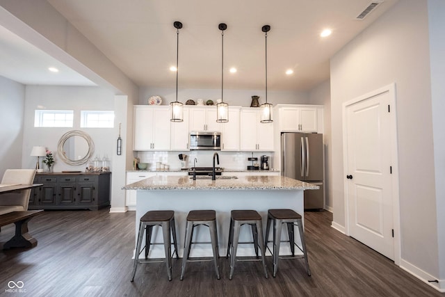 1534 Cloverdon Dr, Westfield, IN 46074 - kitchen with stainless steel appliances, a kitchen breakfast bar, an island with sink, dark wood-style floors, and recessed lighting