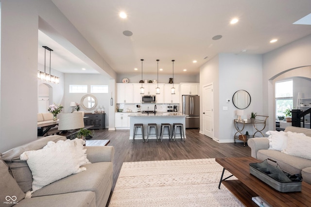 1534 Cloverdon Dr, Westfield, IN 46074 - living room featuring arched walkways, recessed lighting, dark wood finished floors, plenty of natural light, and baseboards