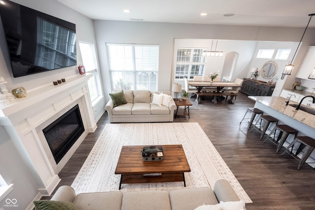 1534 Cloverdon Dr, Westfield, IN 46074 - living area with a high end fireplace, dark wood-style floors, recessed lighting, and arched walkways