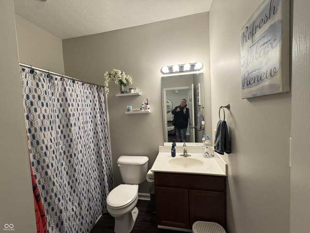 914 Baden Manor Dr, Indianapolis, IN 46217 - bathroom with toilet, vanity, wood finished floors, a shower with curtain, and a textured ceiling