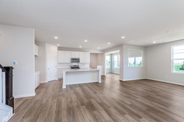 2741 Penn Ave, Plainfield, IN 46168 - kitchen featuring stainless steel microwave, stove, open floor plan, light wood-type flooring, and recessed lighting