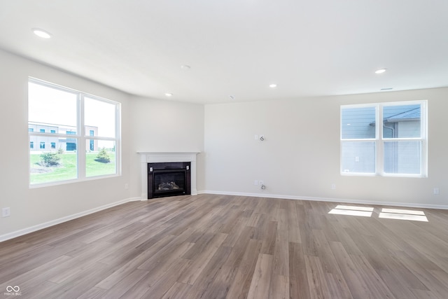 2741 Penn Ave, Plainfield, IN 46168 - unfurnished living room with wood finished floors, a glass covered fireplace, and recessed lighting