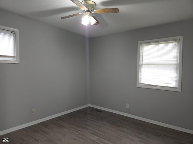 1931 Brentwood Dr, Anderson, IN 46011 - empty room featuring dark wood-type flooring, baseboards, and a healthy amount of sunlight