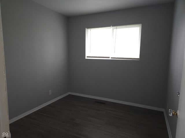 1931 Brentwood Dr, Anderson, IN 46011 - spare room with baseboards, dark wood finished floors, and visible vents