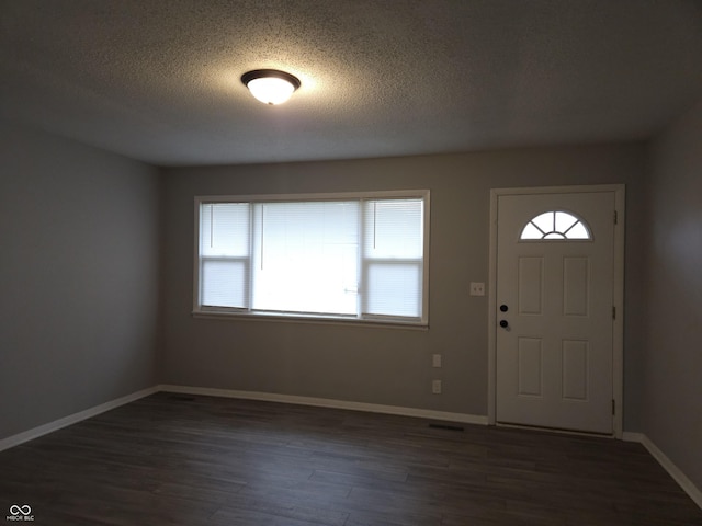 1931 Brentwood Dr, Anderson, IN 46011 - entryway featuring a textured ceiling, baseboards, dark wood-style floors, and visible vents