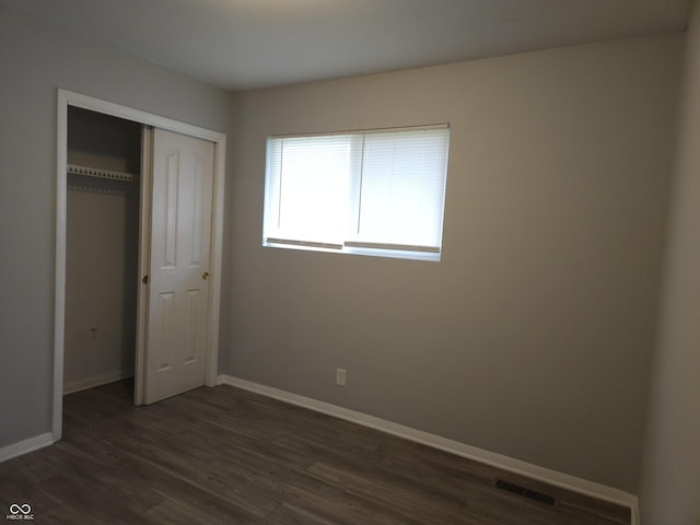 1931 Brentwood Dr, Anderson, IN 46011 - unfurnished bedroom featuring a closet, baseboards, dark wood finished floors, and visible vents