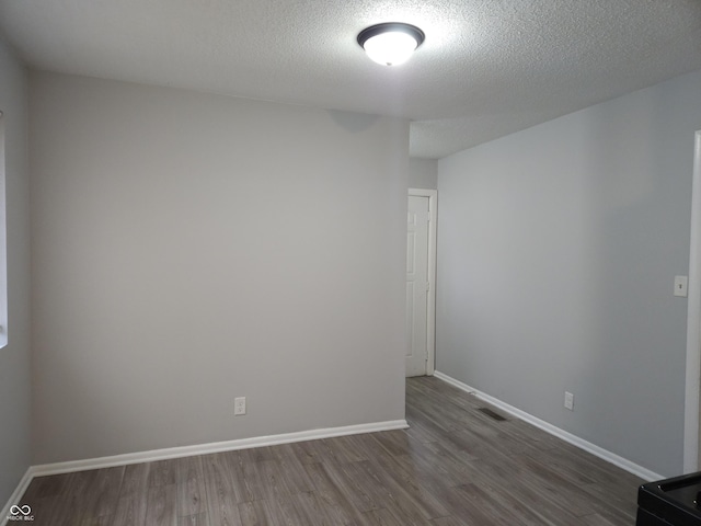 1931 Brentwood Dr, Anderson, IN 46011 - spare room with dark wood-type flooring, visible vents, a textured ceiling, and baseboards